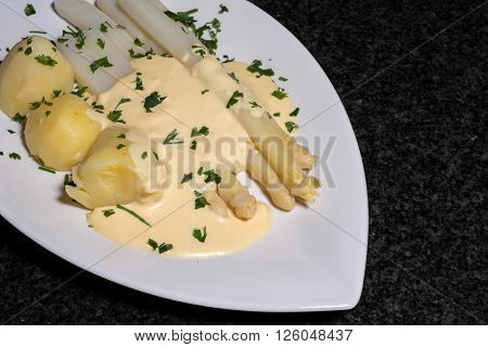 cooked white asparagus with potatoes and parslay