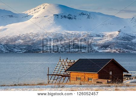 Isolated home and beach on a snowy lake