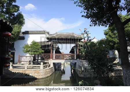 An asian style bridge and architecture over the canals within the water town of Luzhi located in Jiangsu province China.