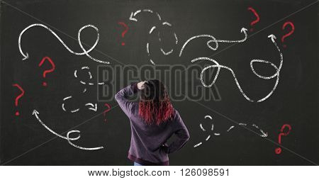 Confused young girl with blackboard drawing different directions and question mark