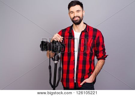 Portrait Of Handsome Young Cameraman Standing In Studio With Camera