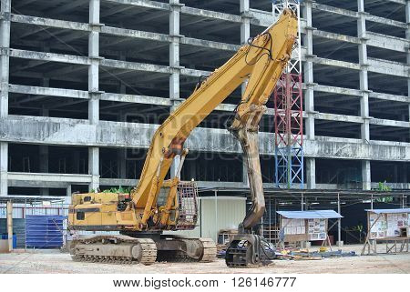 SELANGOR, MALAYSIA -MARCH 25, 2015: Sheet pile cofferdam driven machine at the construction site. The machine drove the sheet pile to the earth using vibrated hydraulic arm. Workers control.
