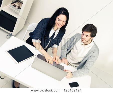 Man and woomen working together. Top view of two young people working together while sitting in minimalistic athmosphere