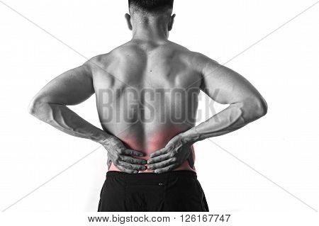 young muscular body sport man holding sore low back waist with hands suffering pain in athlete stress and health care concept isolated background black and white red spot injury