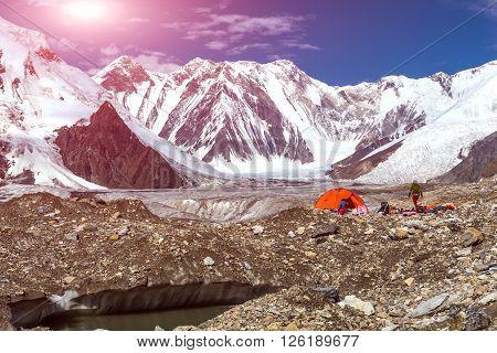 Glacier Crevasse with Melting Water Lake Red Camping Tent Female Hiker and Mountain Panorama with Clean Sky and Shining Sun