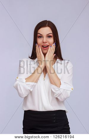 Portrait of surprised business woman on grey background