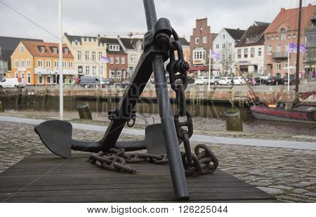 Anchor at Husum harbor with the harbor's houses in backgound