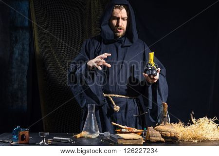 Portrait of a crazy medieval scientist working in his laboratory. Alchemist. Halloween.