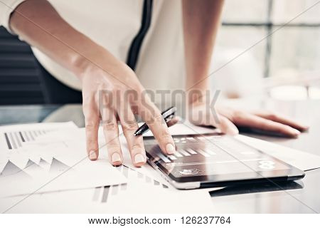 Photo woman reading market reports modern tablet and touching screen with worldwide stock exchange icons. Working process office. Horizontal.