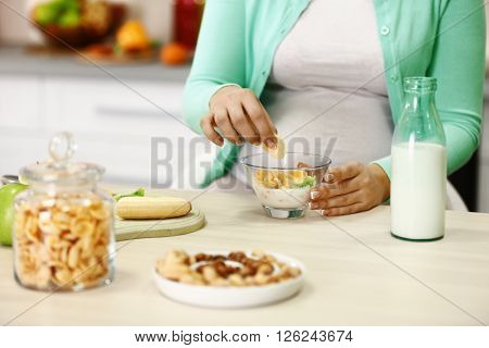 Pregnant woman making breakfast