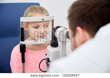 health care, medicine, people, eyesight and technology concept - optometrist with non contact tonometer checking patient intraocular pressure at eye clinic or optics store