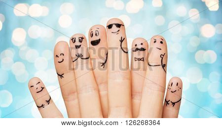 gesture, family, people and body parts concept - close up of two hands showing fingers with smiley faces over blue holidays lights background
