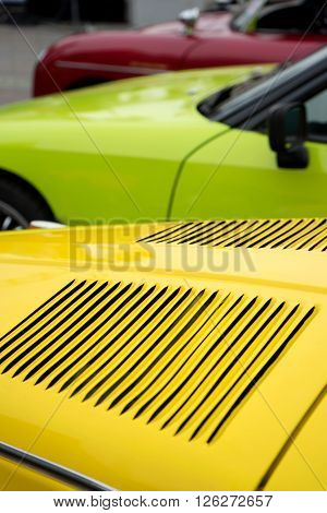 classic car hood yellow green red parking close to gether