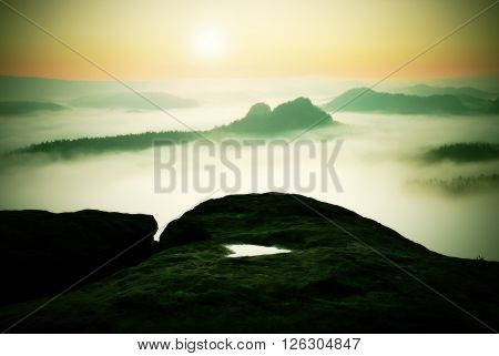 Dreamy Misty Landscape. Majestic Mountain Cut The Lighting Mist. Deep Valley Is Full Of Colorful Fog