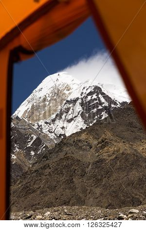 High Mountain Peak and Rock Ridge throw Window Entrance Door of Base Camp Tent Blue Sky and Cloud