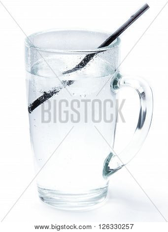 Glass of cold mineral soda water with ice cubes and a cocktail tube isolated on the white background. Mug with crystal clear drinking water cold and refreshing drink.