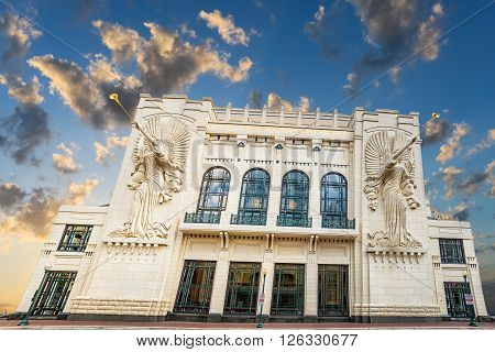 Two angel sculptures with trumpet horns on the front facade of the Bass Performance Hall in Fort Worth TX taken during the twilight hour