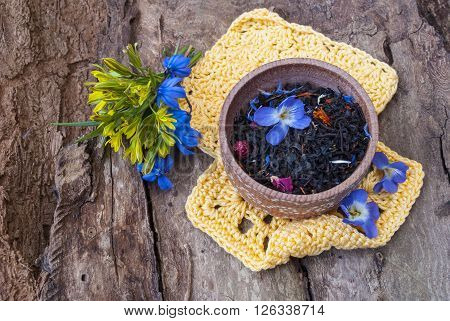 Tea in a wooden bowl on a background of tree bark.