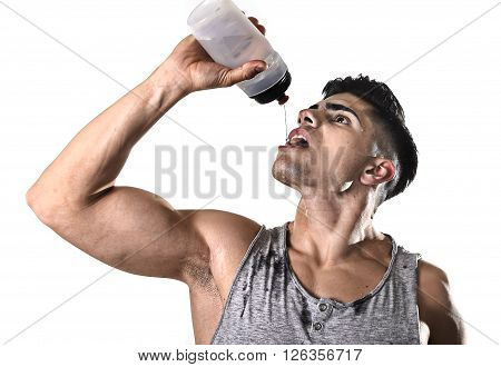 close up portrait of young athletic sport man thirsty drinking water holding the bottle pouring the fluid on his sweaty face refreshing and recovering after hard training workout in hydration concept