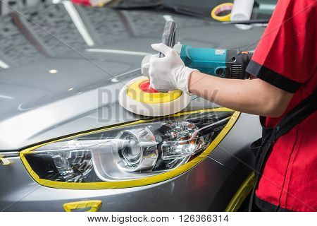 Car detailing series : Worker waxing grey car