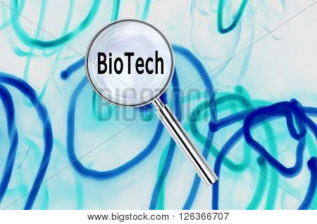 Magnifying lens over background with text BioTech, with the long exposure lights visible in the background.
