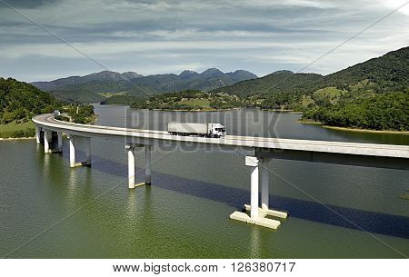 truck outside photography crossing the bridge over the river in sunny day.