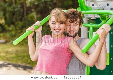 Man And Woman Exercising On Pulldown Outdoor.