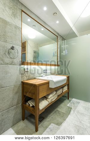 Sink with big mirror and shower cabin in bathroom interior