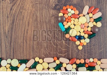 Vintage photo Heart shaped colorful medical pills capsules or supplements for therapy concept of treatment and health care copy space for text or inscription