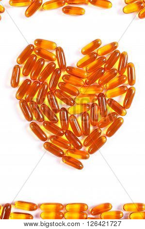 Heart shaped orange medical pills capsules or supplements for therapy on white background concept of treatment