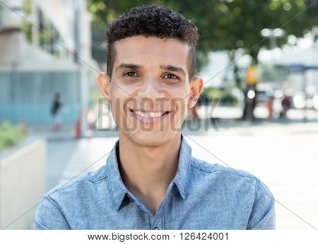 Laughing latin man looking at camera in the city