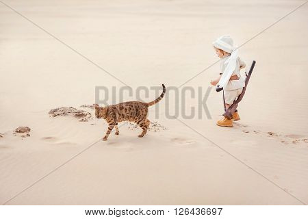 Concept of travel and fascinating adventures. hild in suit of treasures seeker like Indiana Jones in the desert whit wild cat similar to tiger