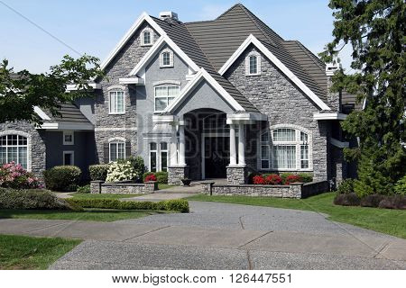 Beautiful luxury mansion with manicured front lawn.