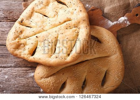 Fugasse French Bread With Sesame Seeds And Herbs Closeup. Horizontal Top View