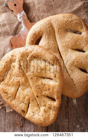 Fugasse French Bread With Sesame Seeds And Herbs Closeup. Vertical Top View