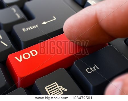 Person Click on Red Keyboard Button with Text VOD - Video on Demand. Selective Focus. Closeup View. 3D Render.