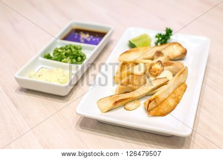 Stir fried eringii mushroom and garlic on white plate Japanese food.