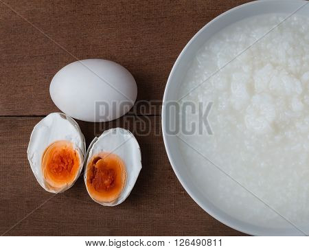 Salted egg and gruel chinese food on wooden background.