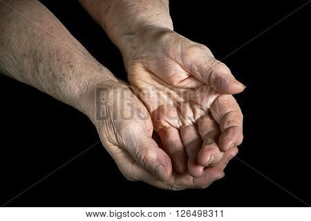 Senior woman hands open on a black background
