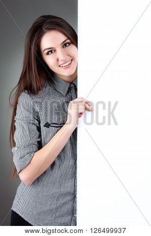 Young woman standing with billboard isolated on white background