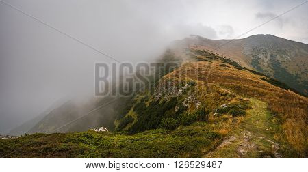 Hiking Trail on the Hill with Fog in the Mountains on Overcast Day