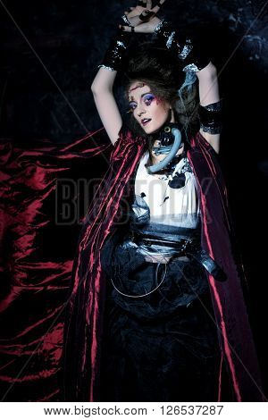 Young woman with creative make up in a red raincoat. Halloween theme. Zombie theme.