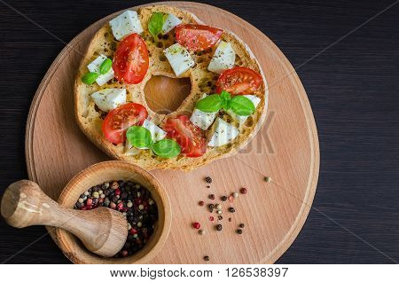 Classical frisella tomato, cheese mozzarella and basil. Italian starter friselle. Dried bread called freselle on wooden board. Italian food. Healthy vegetarian food. Antipasti concept.