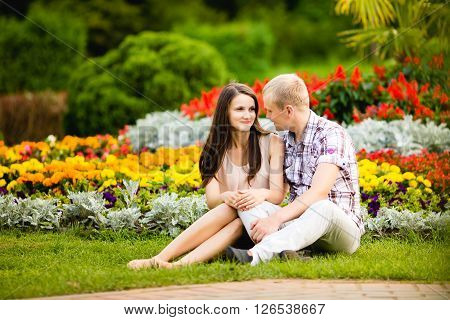 Cute teen couple lovely hugging in the garden flowers outdoors.