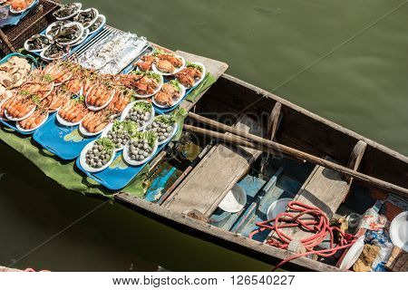 Seafood on trader's boats in a floating market in Thailand. Floating markets are one of the main cultural tourist destinations in Asia.