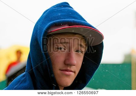 Close-up of handsome teen boy looking at camera in the arin.