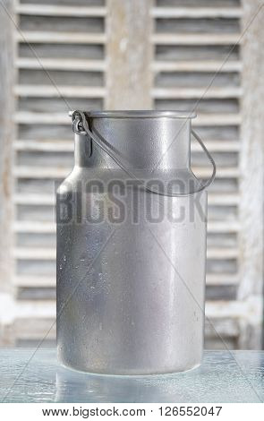 old jug of milk isolated on wooden backgrounf