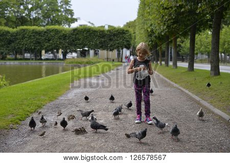 August 2015 - Kadriorg Park, Tallinn, Estonia. A girl is feeding the pigeons in the park.