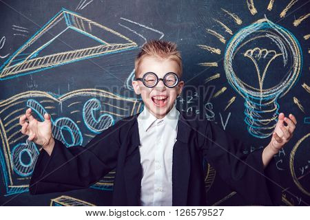 Little boy scientist in glasses cheerfully shouts
