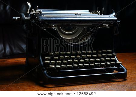 left front of Historic dark typewriter on the wooden table